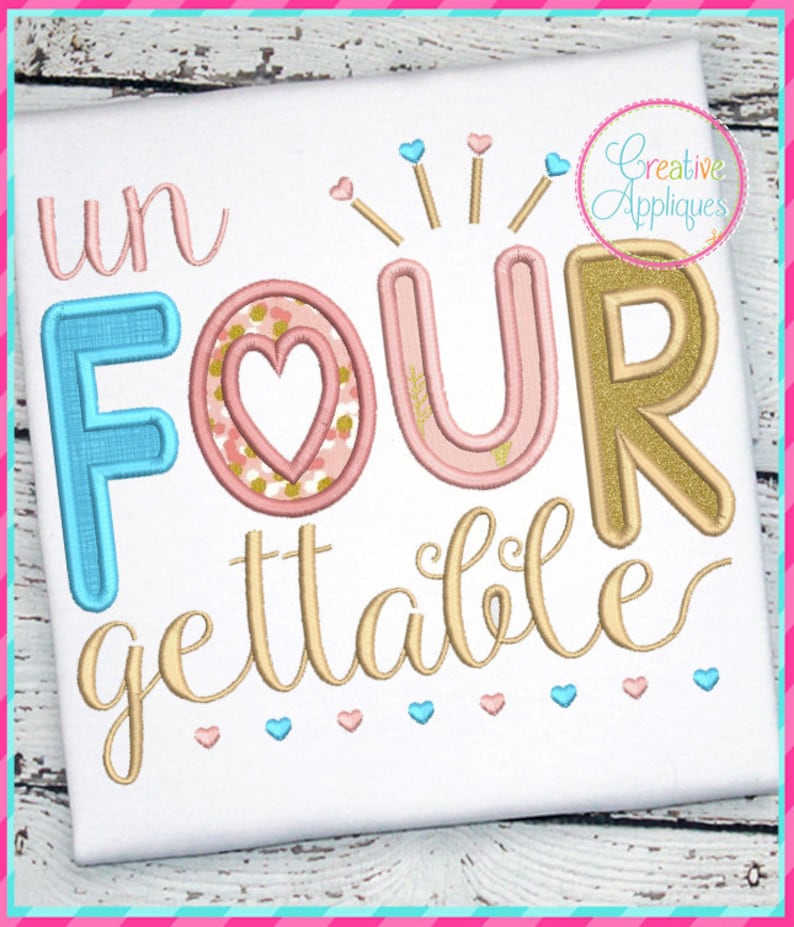 May include: White fabric with the words "un FOUR gettable" embroidered in various colors. The word "FOUR" has a heart in the center. The design includes hearts and starbursts, with the text "Creative Appliques" in a circle.