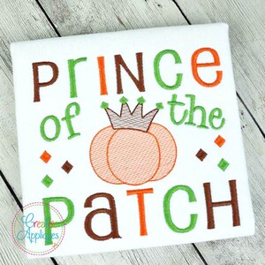 May include: A white onesie with the text "Prince of the Patch" in green, orange, and brown embroidery. A pumpkin with a crown is in the center of the design.