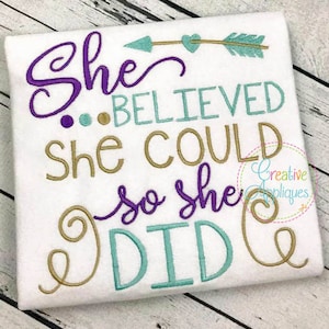 Könnte beinhalten: Ein weißes T-Shirt mit einem gestickten Design, das "She Believed She Could So She Did" lautet. Das Design ist in den Farben Lila, Gold und Türkis gehalten.
