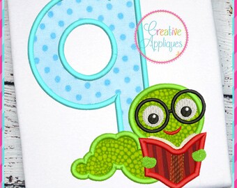 May include: A blue and white polka dot letter Q with a green worm wearing glasses and reading a red book. The worm is smiling and has a happy expression. The text "Creative Appliques" is in a circle on the image.