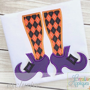 Puede incluir: Diseño bordado de un par de piernas de bruja con medias de rombos negros y naranjas y zapatos morados con punta.