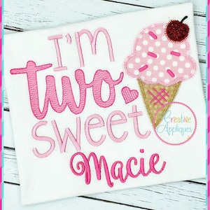 May include: Pink and white embroidered design on a white shirt that says "I'm two sweet Macie" with a pink and white ice cream cone graphic.