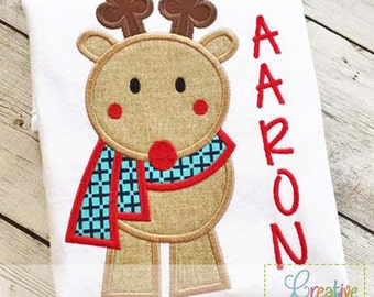 May include: Embroidered design of a brown reindeer wearing a blue and red plaid scarf with the name "AARON" in red lettering.