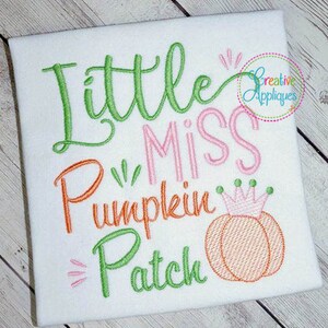 Könnte beinhalten: Weißes besticktes Shirt mit dem Text "Little Miss Pumpkin Patch" in grünem, rosa und orangefarbenem Garn. Auf der rechten Seite des Shirts ist ein kleiner orangefarbener Kürbis mit einer rosa Krone gestickt.
