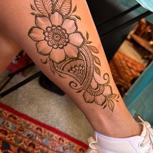 Simple flower henna design on leg