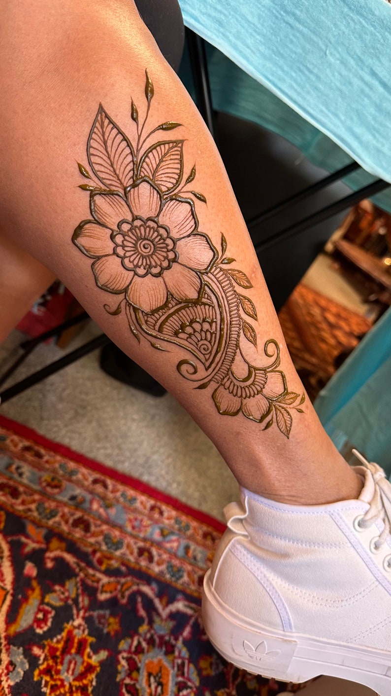 Simple flower henna design on leg