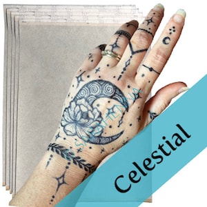 Puede incluir: Un paquete de 6 hojas de papel de transferencia para crear tatuajes temporales. El papel es marr&oacute;n claro y tiene una textura lisa. La imagen muestra una mano con un tatuaje temporal de una luna creciente, estrellas y una flor.