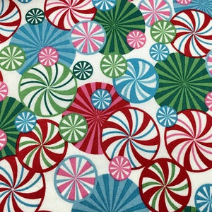 May include: A fabric pattern featuring a repeating design of colorful, circular shapes. The circles are in shades of red, green, blue, and pink, with white backgrounds. The design is reminiscent of peppermint candies.