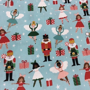 May include: A blue fabric with a repeating pattern of ballerinas, nutcrackers, and presents. The ballerinas are wearing pink, green, and white dresses. The nutcrackers are wearing red and green uniforms. The presents are wrapped in red and green paper.