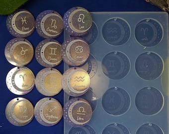 May include: A set of 12 zodiac sign resin molds with a crescent moon design. The molds are clear and have a smooth surface. The zodiac signs are printed in white on the molds. The molds are arranged in a grid pattern on a white surface. The text "Dom's Creations" is printed in black at the bottom of the image.