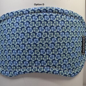 K&ouml;nnte beinhalten: Eine blaue Augenmaske mit einem Blumenmuster in Blau- und Gr&uuml;nt&ouml;nen. Die Maske hat einen wei&szlig; gen&auml;hten Rand und ein kleines schwarzes Etikett mit wei&szlig;em Text, auf dem "KALIOPEL" steht. Der Text "Option D" steht oben.