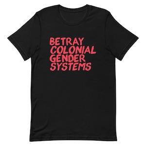 Könnte beinhalten: Schwarzes T-Shirt mit dem Text "Betray Colonial Gender Systems" in Rot.