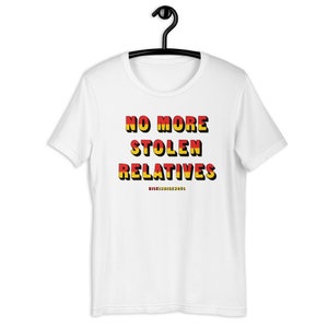 May include: White t-shirt with the text "NO MORE STOLEN RELATIVES" in red and yellow letters with a black outline. The text "RISINGINDIGENOUS" is printed in smaller letters below the main text.