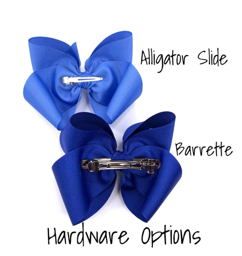 Pu&ograve; includere: Due fiocchi per capelli blu con diverse opzioni hardware. Un fiocco ha una clip a coccodrillo, l'altro una forcina. &Egrave; visibile anche il testo "Alligator Slide", "Barrette" e "Hardware Options".