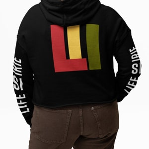 Knit crop pullover hoodie featuring on both sleeves "life is irie" text.  On back featuring the icon graphic in Reggae colors of red, gold, and green.