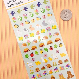 May include: A sheet of colorful stickers featuring various spring-themed designs, including flowers, butterflies, bees, rabbits, hedgehogs, ducks, and bears. The stickers are on a light blue background with the text "chocotto seal series" at the top.