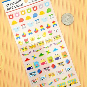 May include: A sheet of colorful stickers featuring various images related to preschool and early childhood education. The stickers include images of hats, uniforms, building blocks, crayons, a butterfly, a duck, a book, a piano, a drum, and a school bus. The text "chocotto seal series" is printed at the top of the sheet.