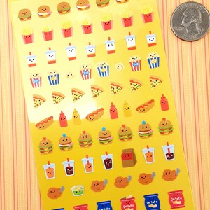 May include: A sheet of colorful stickers featuring various cartoon food items, including burgers, fries, pizza, hot dogs, donuts, ice cream cones, and more. The stickers are on a yellow background with the text "たべられ隊 TABERARET&Alpha;&Iota;" and "じゃんくふーど" in Japanese. The text "Made in Japan" is at the bottom of the sheet.