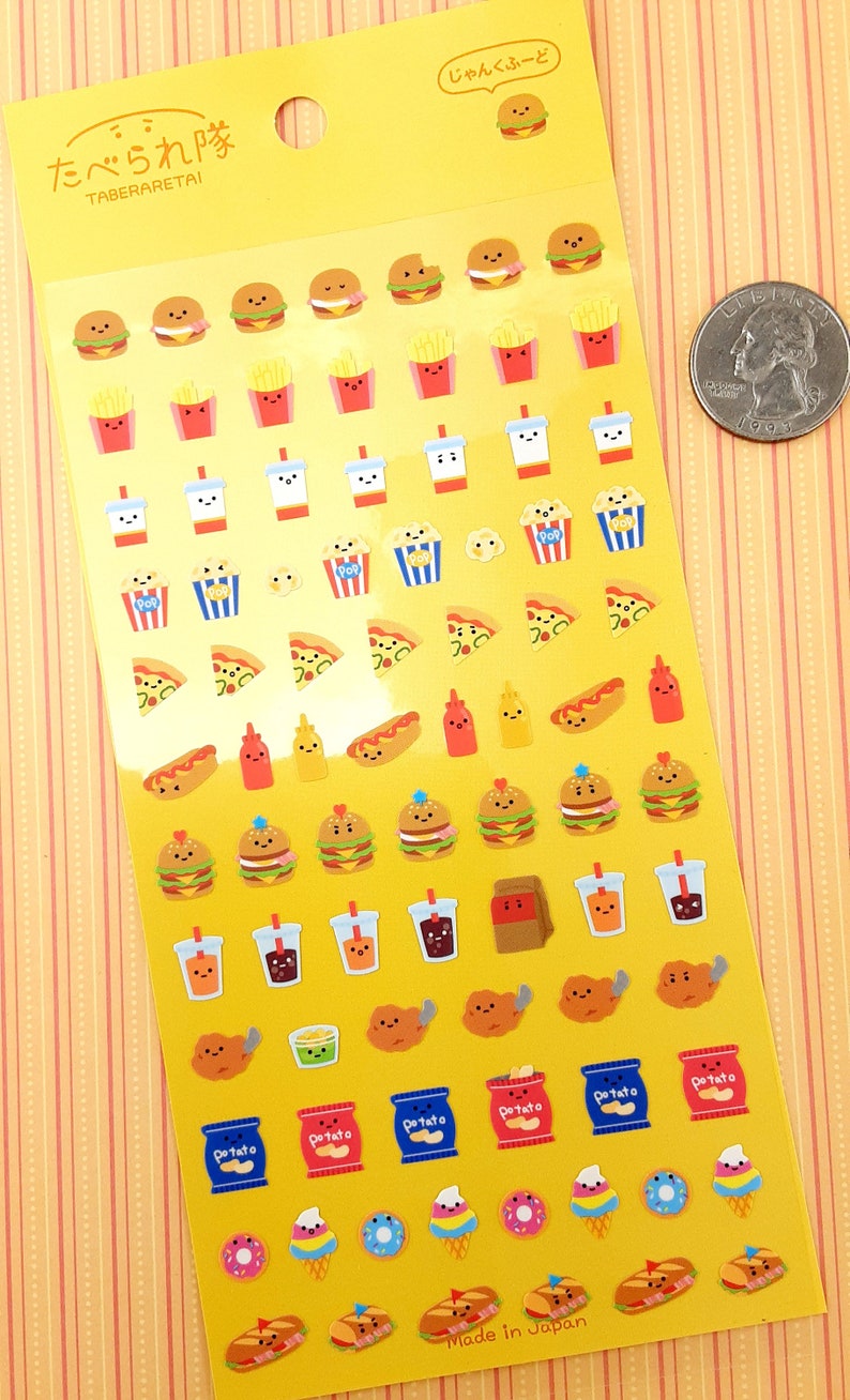 May include: A sheet of colorful stickers featuring various cartoon food items, including burgers, fries, pizza, hot dogs, donuts, ice cream cones, and more. The stickers are on a yellow background with the text "たべられ隊 TABERARET&Alpha;&Iota;" and "じゃんくふーど" in Japanese. The text "Made in Japan" is at the bottom of the sheet.