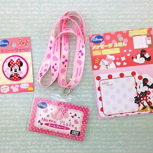 Può includere: Un laccio, un porta badge e un pacchetto di 50 note adesive a tema Minnie Mouse in rosa e bianco. Le note adesive presentano un design di Minnie Mouse e pois. Il testo sulla confezione recita "Disney Message Notes 50 Count".