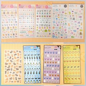 Puede incluir: Un conjunto de diez hojas de pegatinas coloridas con varios diseños de animales. Las pegatinas están organizadas en dos filas de cinco hojas. La fila superior presenta pegatinas con pingüinos, búhos y leones. La fila inferior presenta pegatinas con gatos, pingüinos, búhos y erizos.
