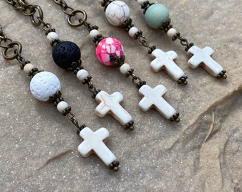 May include: Five silver chains with white cross charms and various colored beads. The beads include white, black, pink, and green.