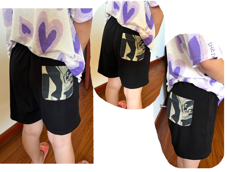 May include: Black shorts with a large, colorful pocket on the back. The pocket has a graphic design of a person with a hat and a flower.