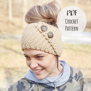 Puede incluir: Una diadema de crochet beige con dos botones marrones. La diadema la lleva puesta una persona con un moño. El texto "PDF CROCHET PATTERN" es visible en la imagen.