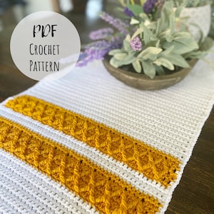 Könnte beinhalten: Ein weißer Häkeltischläufer mit zwei gelben Häkelstreifen. Der Text "PDF CROCHET PATTERN" befindet sich auf einem weißen Kreis in der oberen linken Ecke des Bildes.