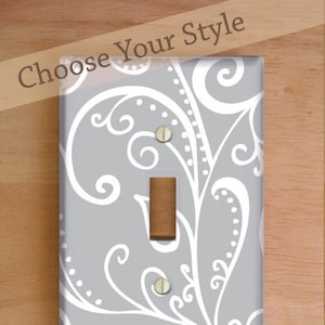 May include: Three different switch plate covers with a gray and white damask pattern. The covers are labeled "Standard Cover", "Decora/Rocker Cover", and "Outlet Cover".