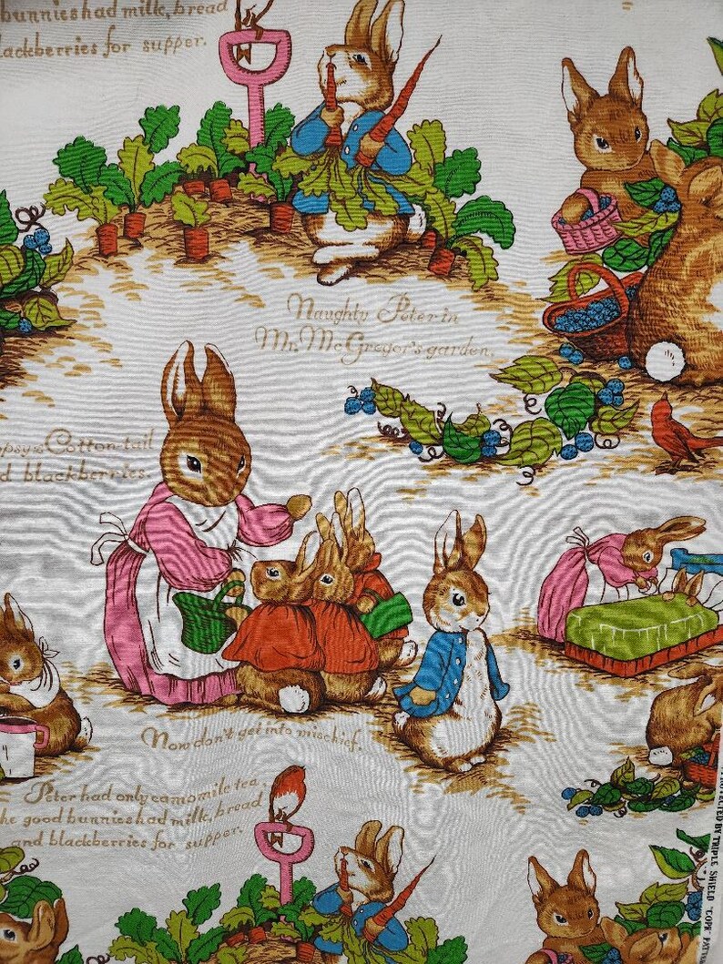 May include: A white fabric with a repeating pattern of brown rabbits, green plants, and red carrots. The text "Naughty Peter in Mr. McGregor's garden" is printed on the fabric.