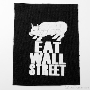 Peut inclure: Patch noir et blanc avec un taureau de dessin animé et le texte "EAT WALL STREET".