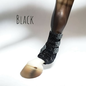 May include: Black horse leg boot with a black and gray patterned design. The boot has a velcro closure.