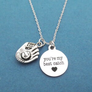 May include: Silver necklace with a baseball glove charm and a round pendant that says "you're my best catch" with a small heart.