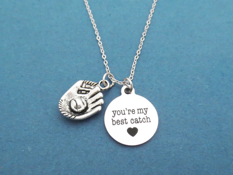 May include: Silver necklace with a baseball glove charm and a round pendant that says "you're my best catch" with a small heart.
