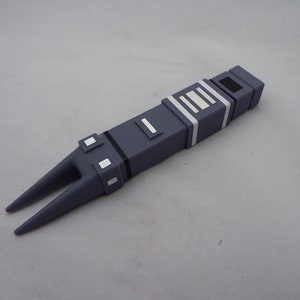 May include: A gray plastic toy spaceship with a pointed nose and a series of white stripes on the side.