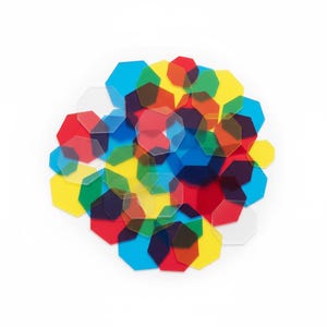 May include: A collection of colorful, translucent, octagonal shapes in red, blue, yellow, and clear. The shapes are scattered on a white background, creating a vibrant and playful visual.
