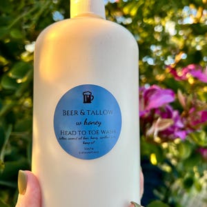 May include: A white bottle of "Beer & Tallow w honey HEAD TO TOE WASH" soap with a blue label. The label includes a beer mug graphic and the words "Soap & Shenanigans". The bottle has a white pump dispenser.