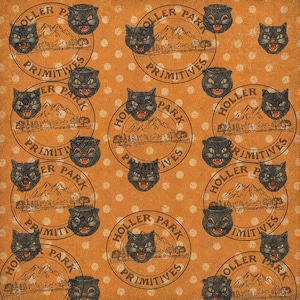 May include: A patterned fabric or paper featuring a repeating design of black cat faces with green eyes and open mouths, interspersed with circular stamps that contain a mountain landscape and the text Holler Park Primitives on orange.