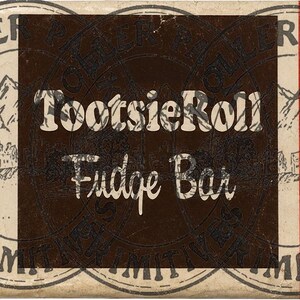 Puede incluir: Un envoltorio rectangular de Tootsie Roll Fudge Bar con un cuadrado central marr&oacute;n oscuro y texto en blanco. El fondo es de color blanco roto con dos franjas rojas verticales y sellos circulares con el texto BIG TWIN PRIMITIVES e im&aacute;genes de monta&ntilde;as.