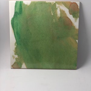 Puede incluir: Pintura abstracta sobre un lienzo blanco con pintura verde, marr&oacute;n y blanca. La pintura verde es el color dominante y se extiende sobre el lienzo en un estilo suelto y fluido. La pintura marr&oacute;n se utiliza con moderaci&oacute;n y crea un contraste sutil con el verde. La pintura blanca se utiliza para crear luces y acentos.