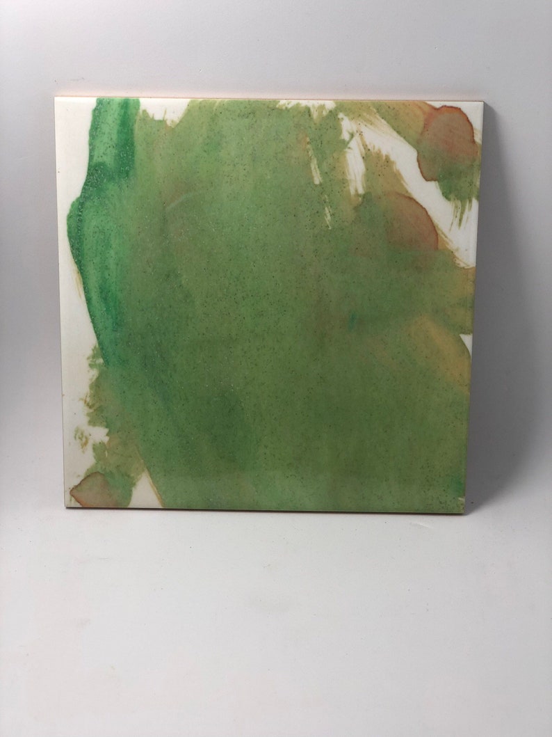 Puede incluir: Pintura abstracta sobre un lienzo blanco con pintura verde, marr&oacute;n y blanca. La pintura verde es el color dominante y se extiende sobre el lienzo en un estilo suelto y fluido. La pintura marr&oacute;n se utiliza con moderaci&oacute;n y crea un contraste sutil con el verde. La pintura blanca se utiliza para crear luces y acentos.