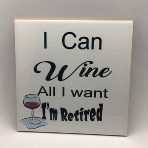 Puede incluir: Azulejo de cer&aacute;mica blanco con texto negro que dice "I Can Wine All I Want I'm Retired". Una ilustraci&oacute;n en blanco y negro de una copa de vino con vino tinto est&aacute; a la izquierda del texto.