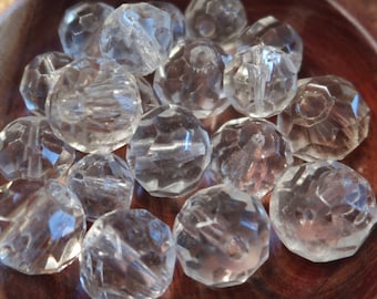 May include: A bowl of clear faceted glass beads. The beads are round and have a shiny finish.