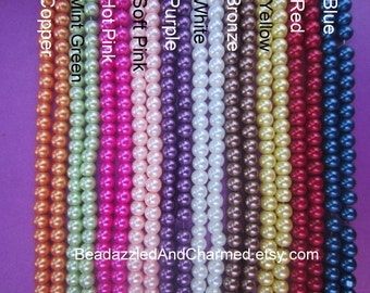 May include: A selection of 10 strands of pearl beads in various colors, including copper, mint green, hot pink, soft pink, purple, white, bronze, yellow, red, and blue. The beads are all the same size and are arranged in a row. The text "BeaddazzledAndCharmed.etsy.com" is visible at the bottom of the image.