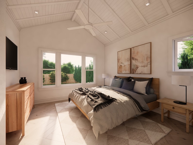May include: A bright, airy bedroom with a vaulted, white-paneled ceiling and a large window overlooking greenery. The room features a wooden bed frame, a dresser, and a nightstand. A ceiling fan and two abstract paintings add to the room's decor.
