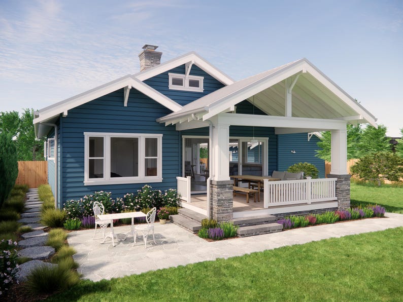 May include: A blue house with white trim, a porch, and a stone patio. The house has a gabled roof and a chimney. White chairs and a table are on the patio. Landscaping includes flowers and a green lawn.
