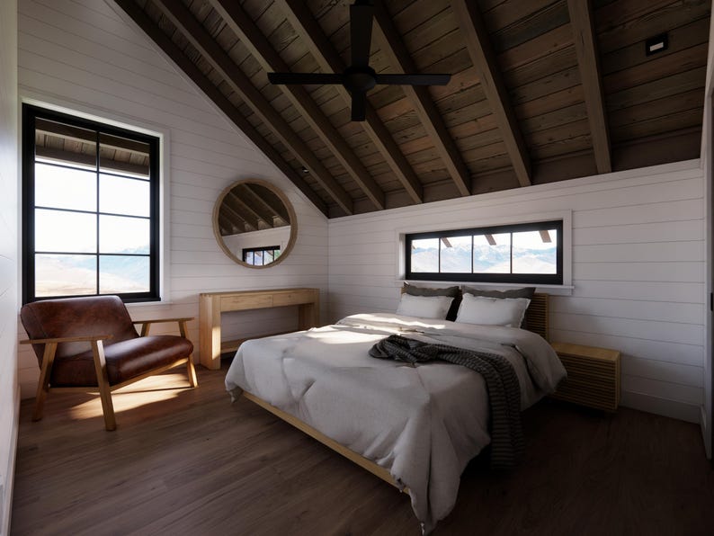 May include: Bedroom interior with a bed, chair, and window. The room features a wooden ceiling and floor, with white walls. A round mirror hangs on the wall. The bed has white bedding and a dark gray blanket.
