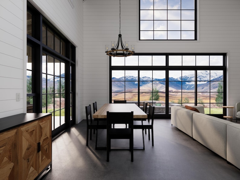 May include: A modern dining room with a large window overlooking a mountain range. The room features a wooden dining table with six black chairs, a white sofa, and a wooden cabinet. A chandelier hangs above the table.