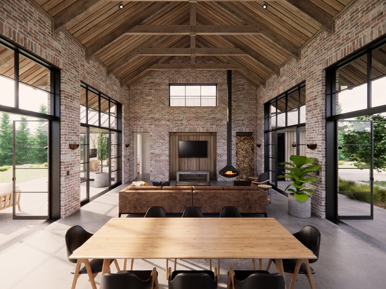 A living and dining rustic barn style home interior with very high ceilings, exposed timber trusses and reclaimed brickwork walls. Large steel windows flank both sides of the living spaces.